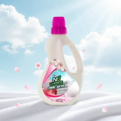 NuChoice Fabric Softener bottle with pink cap and floral design, displayed on soft white fabric against a bright sky background with floating cherry blossoms.